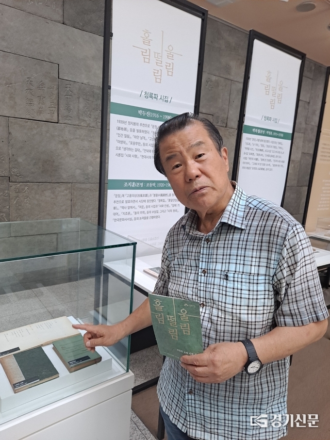  김훈동 시인이 ‘홀림·떨림·울림’ 전시회 서적에 대해 설명하고 있다. (사진=정창규 기자)