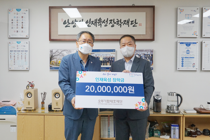 안양인재육성재단 천기철(왼쪽) 대표가 오뚜기 함태호재단 김봉진 차장으로부터 장학금을 기탁받고 있다.(사진=안양인재육성재단 제공)