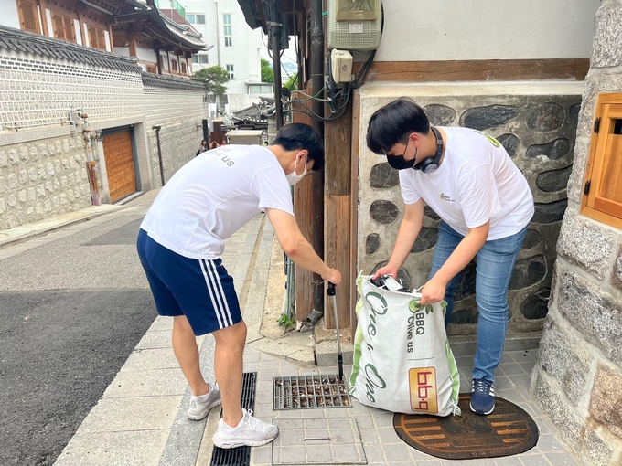 BBQ 대학생 봉사단 올리버스 단원들이 북촌 한옥마을에서 쓰레기를 줍고 있다. (사진=제너시스 BBQ 제공)