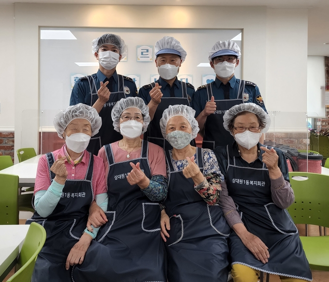 (사진 뒷줄 왼쪽부터)이승운 순경, 이광덕 경위, 천정희 경장 등이 어르신 급식봉사활동에 참여한 자원봉사자들과 함께 화이팅을 하고 있다. (사진=상대원2파출소 제공) 