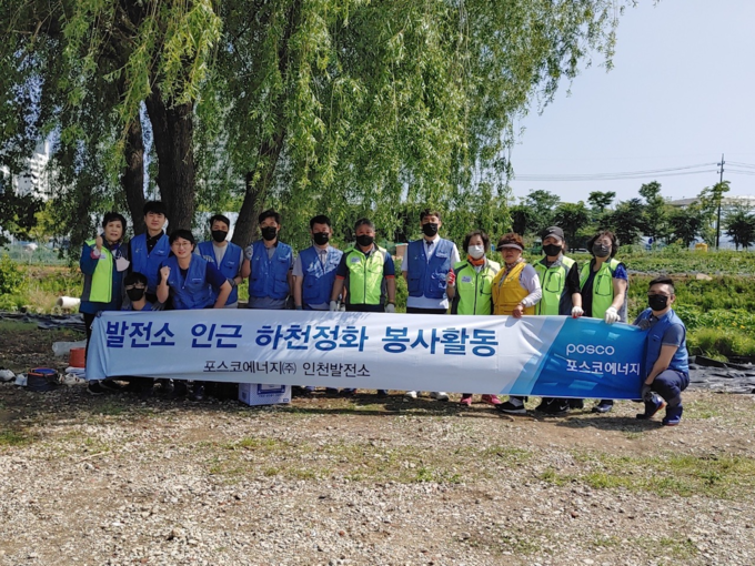 포스코에너지 인천발전소 직원들이 서구 공촌천에서 창포꽃 가꾸기 활동을 한 뒤 기념촬영을 하고 있다. ( 사진 = 포스코에너지 제공 )