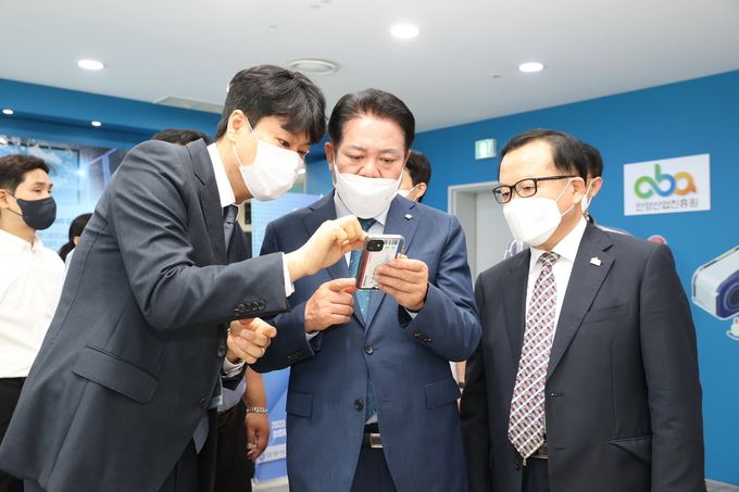 최대호(가운데) 안양시장이 비대면 화상 수출상담회장을 찾아 기업 관계자로부터 제품이 대한 설명을 듣고 있다.(사진=안양시청 제공)