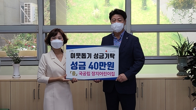 김동진 장지어린이집 원장이 어려운 이웃을 위해 사용해 달라며 이강건 복지국장에게 성금을 기탁하고 있다.(사진=광주시 제공)