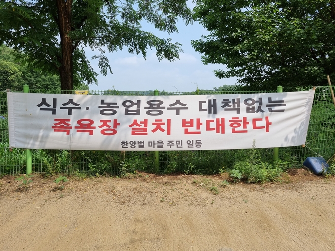 남양주시가 주민의견 수렴없이 한양벌 마을에 족욕장 설치를 추진하자 주민들이 반대 현수막을 설치하는 등 반발하고 있다.(사진=이화우 기자)