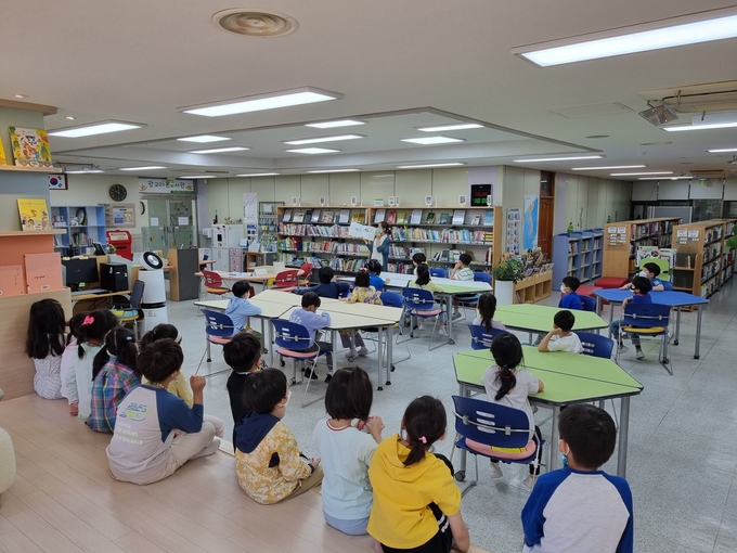 라온도서관에서는 사서와 어머니들이 아이들에게 책을 읽어주는 활동을 하고 있다. (사진=수원광교초등학교 제공)