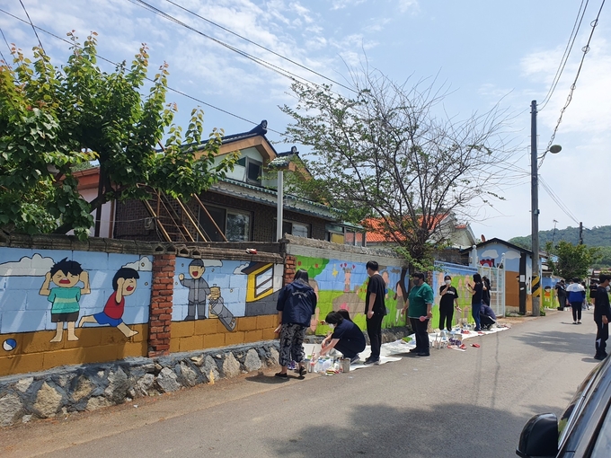 파주시 새경고교생들이 마을결합현 교육 일환으로 벽화그리기를 하고 있다.(사진=파주시 제공)