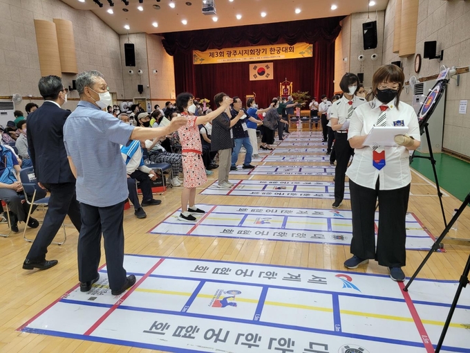 대한노인회 광주시지회 한 어르신이 한궁대회에 참석해 참가자들과 실력을 겨루고 있다.(사진=광주시 제공)