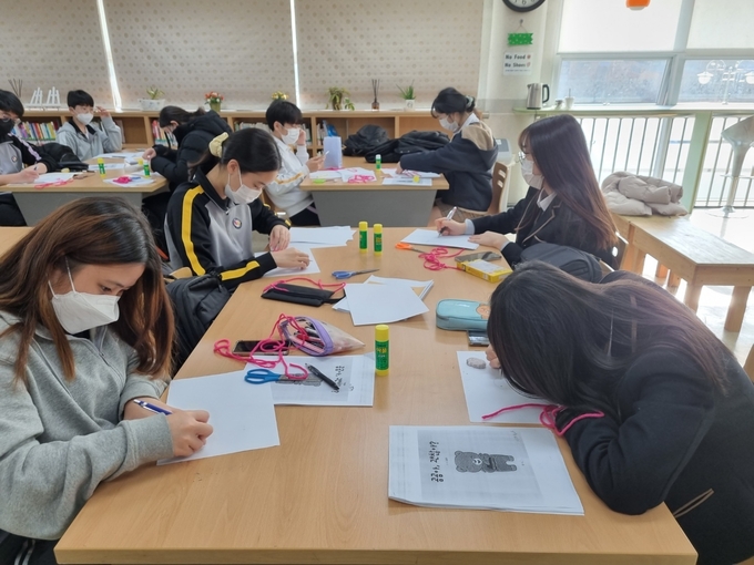 학생들이 털실과 드로잉 북을 이용한 ‘그림책 처방전’ 프로그램을 체험하고 있다. (사진=광명충현중학교 제공)