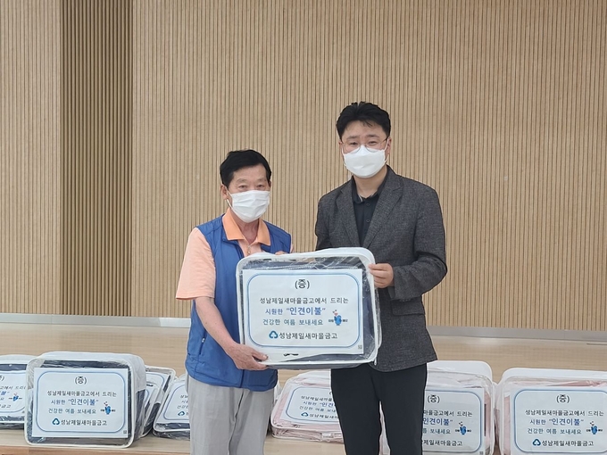 이순규 산성동 지역사회보장협의체 민간위원장(사진 오른쪽)이 여름이불 전달식에 참여하고 있다. (사진=성남시 제공)