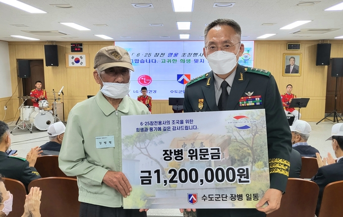 고창준 군단장이 참전용사에게 장병들이 모금한 위문금을 전달하고 있다.(사진=육군 수도군단 제공) 
