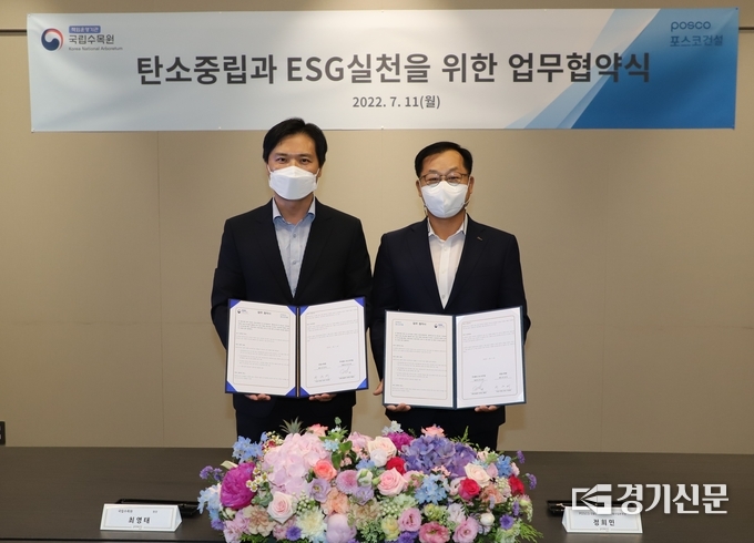 최영태 국립수목원 원장(왼쪽)과 한성희 포스코건설 대표이사를 대신해 서명한 정희민 건축사업본부장이 협약서를 들어보이고 있다. (사진=국립수목원 제공)