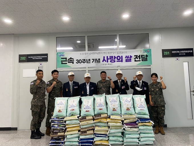 육군제2기갑여단 박성민 원사(사진 중앙)가 6.25참전용사께 쌀을 기부하고 있다.(사진=2기갑여단 제공)