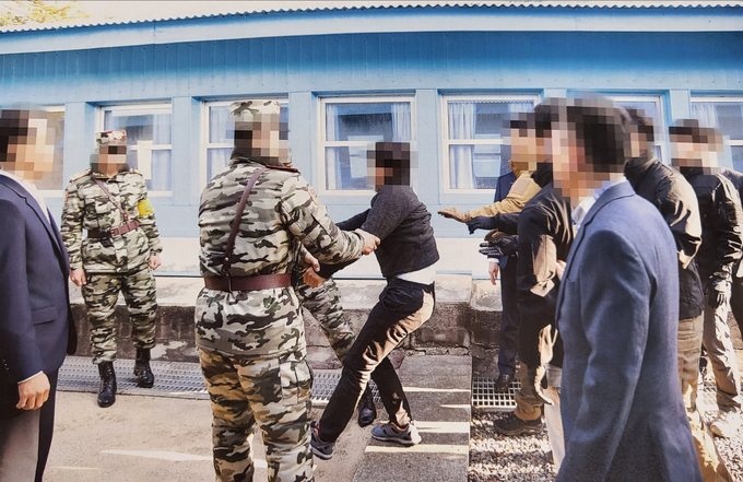 통일부는 지난 2019년 11월 판문점에서 탈북어민 2명을 북한으로 송환하던 당시 촬영한 사진을 12일 공개했다. 당시 정부는 북한 선원 2명이 동료 16명을 살해하고 탈북해 귀순 의사를 밝혔으나 판문점을 통해 북한으로 추방했다. 사진은 탈북어민이 몸부림치며 북송을 거부하는 모습. (사진=통일부 제공)