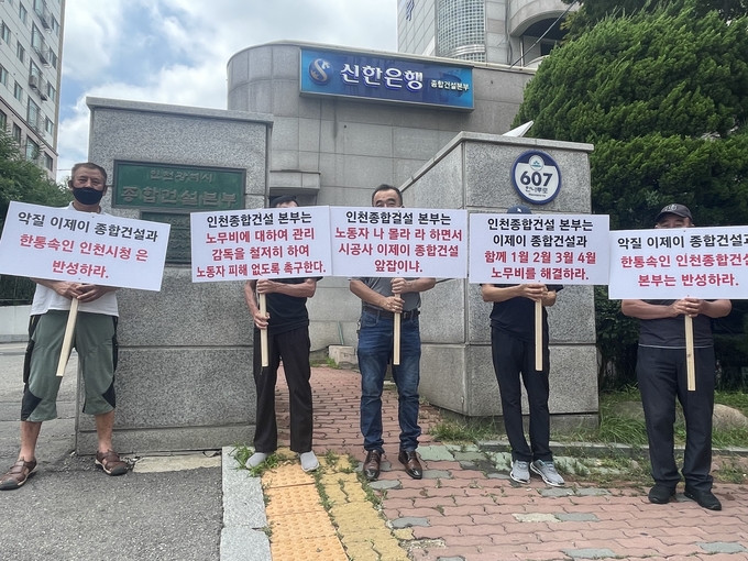 인천유나이티드FC 축구센터 건설 공사에 참여한 노동자들이 14일 인천시 종합건설본부 앞에서 피켓을 들고 집회를 진행 중이다. ( 사진 = 조경욱 기자 )