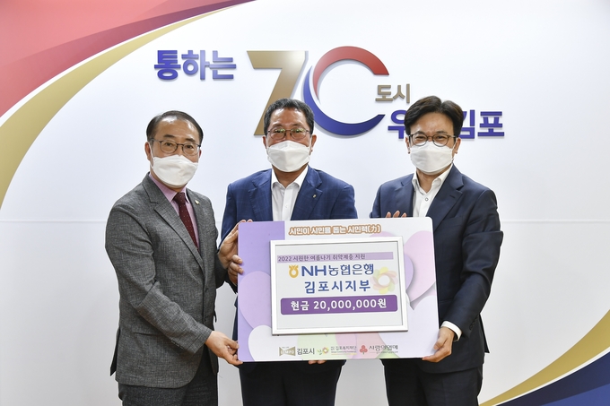 농협은행 김포지부 권오현 지부장(중앙)이 복지재단 이사장 김병수 시장(오른쪽)을 통해 관내 취약계층에 전달 해달라며 2000만원을 기탁하고 있다.(사진=NH농협은행 김포시지부 제공)