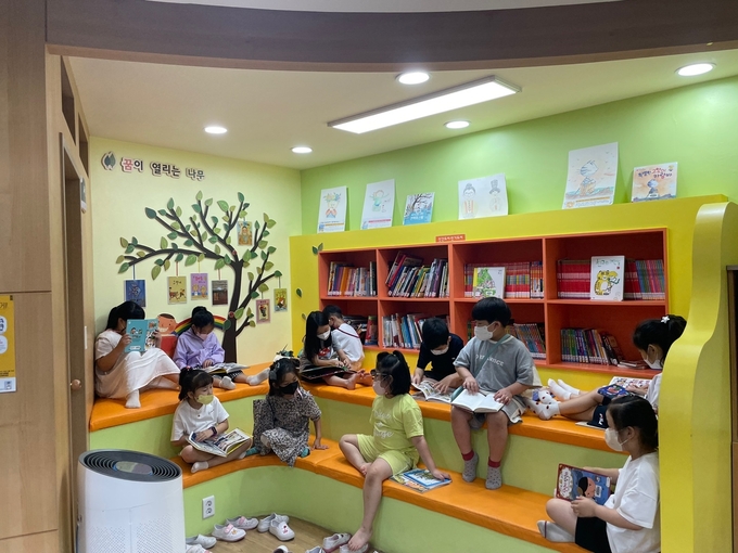  평택덕동초등학교 학생들이 ‘꿈이 열리는 나무’에 모여 독서를 즐기고 있다. (사진=평택덕동초등학교 제공)