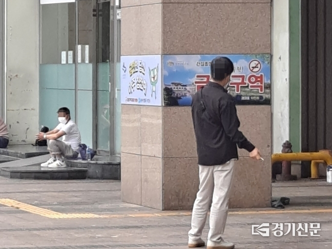  수원역 인근 상가 거리에 한 시민이 흡연구역이 없어 길거리에서 담배를 피고 있다. (사진=정창규 기자)