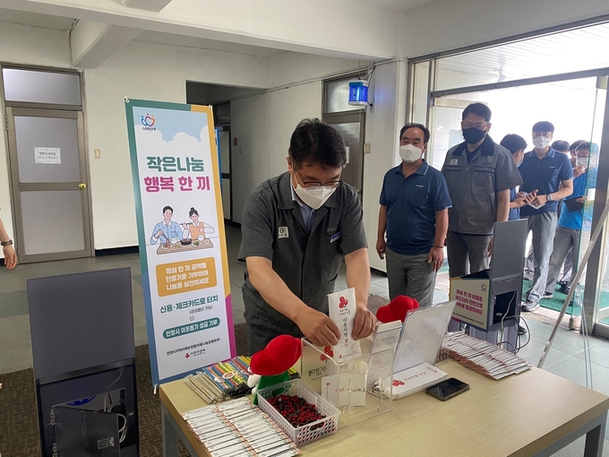(주)효성공장에서 열린 '작은 나눔, 행복 한 끼' 캠페인에 임직원들이 줄을 서서 참여하고 있다.(사진=안양시 제공)