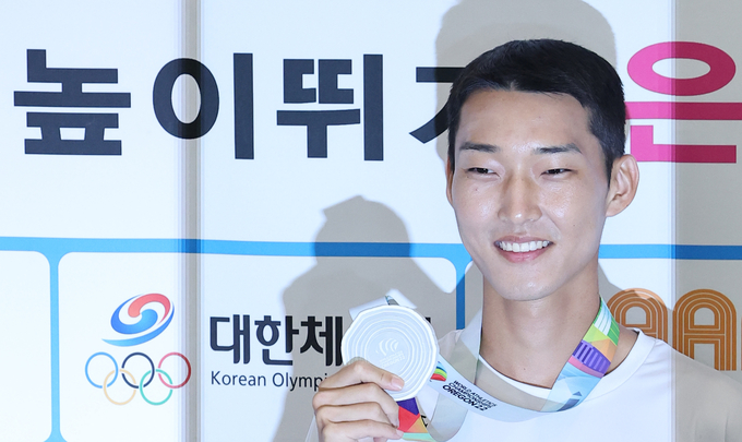 한국 육상 첫 '세계선수권대회 은메달'을 획득한 남자 높이뛰기 우상혁이 21일 오후 인천국제공항 제2여객터미널을 통해 귀국하며 인터뷰에 앞서 메달을 들어 보이고 있다. 우상혁은 19일(한국시간) 미국 오리건주 유진 헤이워드 필드에서 열린 2022 세계육상선수권대회 남자 높이뛰기 결선에서 2m35로 2위를 차지했다. (사진=연합뉴스 제공)
