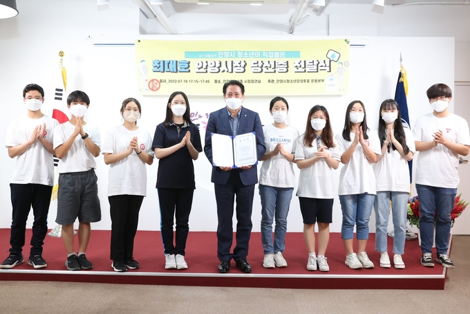최대호 안양시장이 청소년모의투표 안양운동본부로부터 당선증을 받고 청소년들과 기념사진을 찍고 있다.(사진=안양시 제공)
