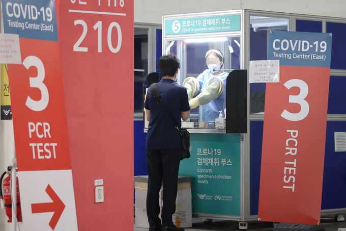 한 해외입국자가 24일 인천국제공항 제2여객터미널 동편 입국자 코로나19 검사센터에서 검체를 채취하고 있다. 인천국제공항은 지난 19일 제2여객터미널 동편에 입국자용 코로나19 검사센터를 추가로 설치해 운영 중이라고 밝혔다. (사진=연합뉴스)
