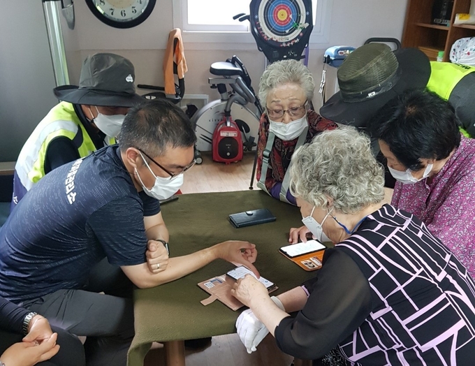 행궁동 경기행복마을관리소 관계자가 경로당을 찾아 어르신들에게 스마트폰 보안에 대해 설명하고 있다. (사진=수원시 제공)