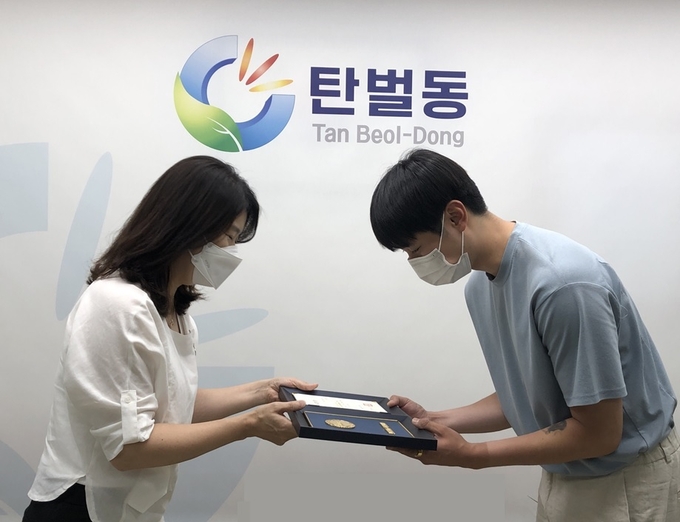이성은 (좌쯕)동장이 화재에 신속한 초기 진화 활동을 펼친 김동진 시민에게 선행도민 표창장을 전수하고 있다.(사진=광주시 제공)