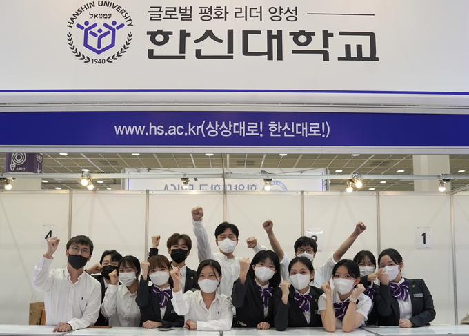 ‘2023 수시 대학입학정보박람회’에 설치된 부스에서 한신대 관계자들이 단체사진을 찍고 있다.(사진=한신대학교 제공)