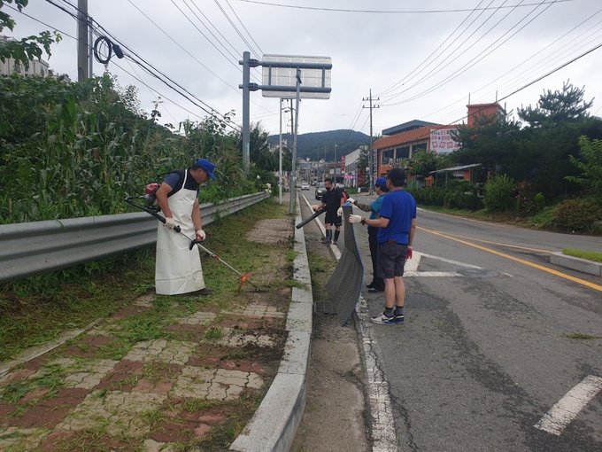 오포읍 능평2리 부녀회와 개발위원회 회원들이 관내 회전교차로 등 주변 도로에서 예초 작업을 하고 있다.(사진=광주시 제공)
