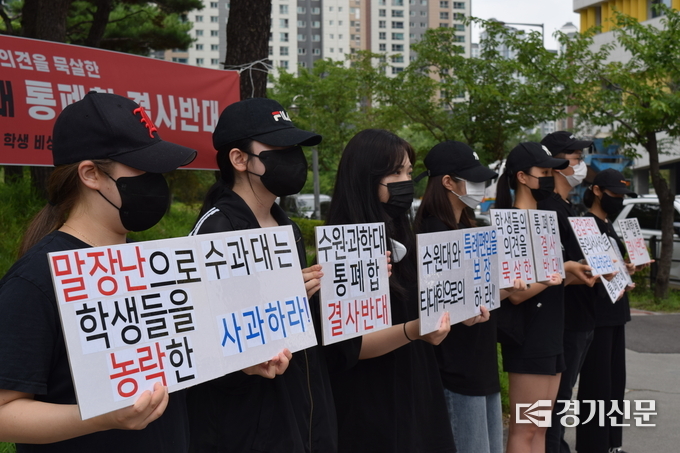 27일 수원과학대학교 학생비상대책위원회가 ‘수원대학교-수원과학대학교 통폐합 결사반대’ 집회에서 손팻말을 들고 있다. (사진=임석규 기자)