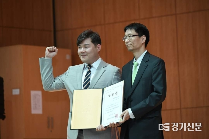 선관위원장에게 당선증을 교부받고 오른손을 번쩍 들어 보이고 있다. (사진=문석완 기자)