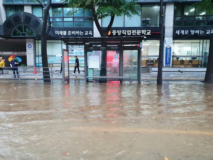인천 남동구 구월동 시청입구삼거리 방면 도로가 침수돼 빗물이 도보까지 침범했다. ( 사진 = 조경욱 기자 )