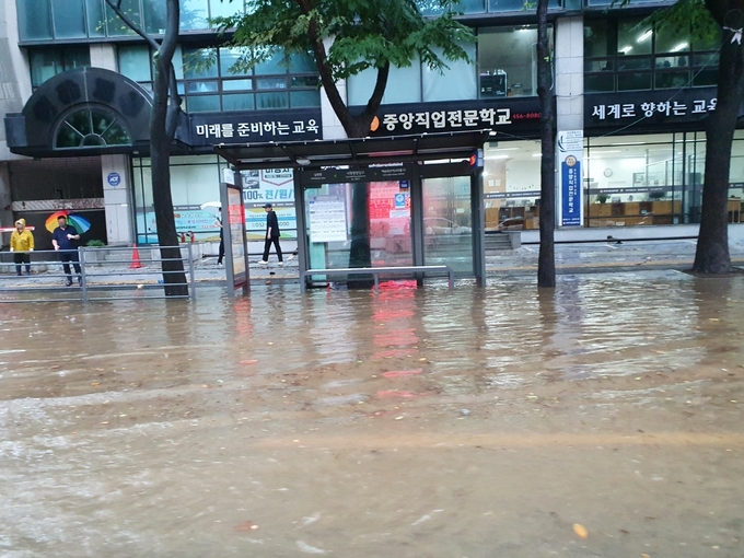 인천 남동구 구월동 시청입구삼거리 방면 도로가 침수돼 빗물이 도보까지 침범했다. ( 사진 = 조경욱 기자 )
