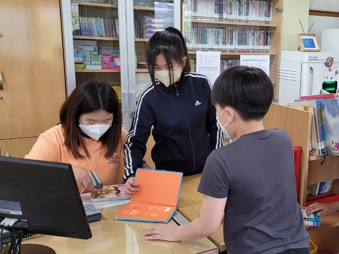  도서관을 관리하고 학생들의 도서 대출‧반납을 돕고있는 즐거운 도서관 ‘어린이 사서’. (사진=화성화산초등학교 제공)