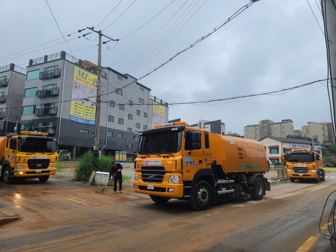 파주도시관광공사가 집중호우로 토사가 뒤덮은 도로를 살수차를 동원해 정비하고 있다(사진=파주도시관광공사 제공)
