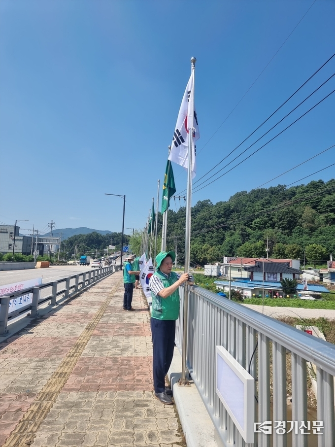 포천시새마을회 이경묵 회장이 용정교 개양대에 태극기를 달고 있다. (사진=포천시 제공)