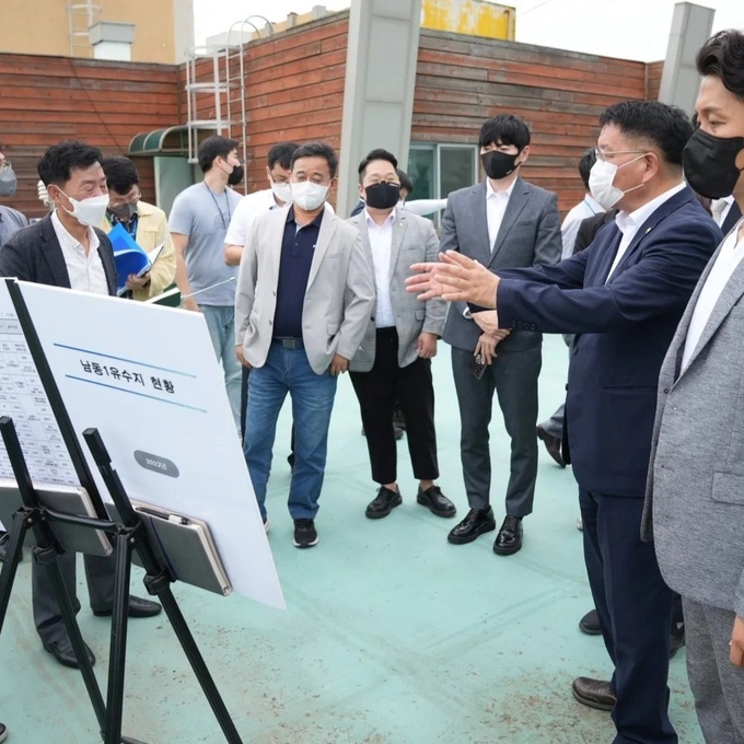 인천시의회 의원들이 지난달 남동유수지 현장에 방문해 현황 설명을 듣고 있다. ( 사진 = 인천시의회 제공 )
