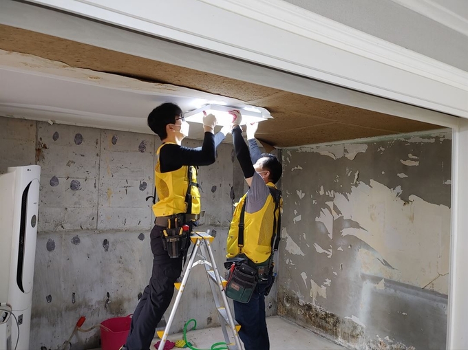 한국전기공사협회 경기중부회 회원과 안양시 전기직 공무원들이 침수주택의 전기시설 복구작업을 벌이고 있다.(사진=안양시 제공)