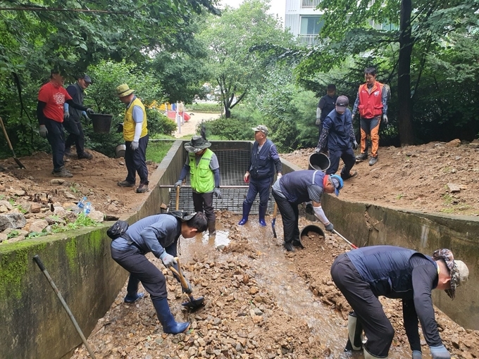 집중후우로 산책로 배수로가 막혀 피해가 발생했던 현장에 공원녹지과 복구 응급팀이 나서 정비하고 있다. 공원녹지과 제공
