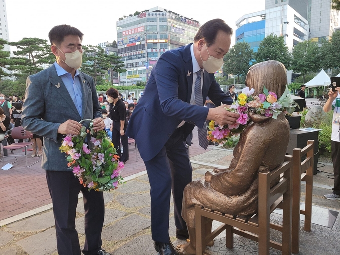 이권재 오산시장과 성길용 오산시의회 의장이 오산평화의소녀상에게 헌화하고 있다(사진=오산시 제공)