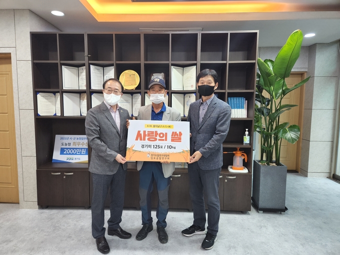 김포금쌀연구회 자영철(중앙)회장이 농업기술센터에 사랑의 쌀을 기탁하고 기념사진을 찍고 있다.(사진= 농업기술센터 제공)