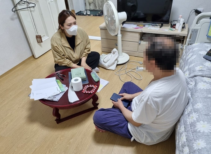 인천 남동구 관계자가 지난 6월 알코올 중독으로 치료를 받다가 퇴원한 한 홀몸 노인과 상담을 진행하고 있다. ( 사진 = 남동구 제공 )