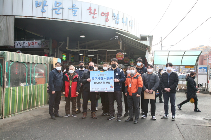 현제제철 임직원들이 전통시장에서 장보기 상품권을 전달하며 상인들과 함께 사진촬영을 하고 있다. ( 사진 = 현대제철 제공 )