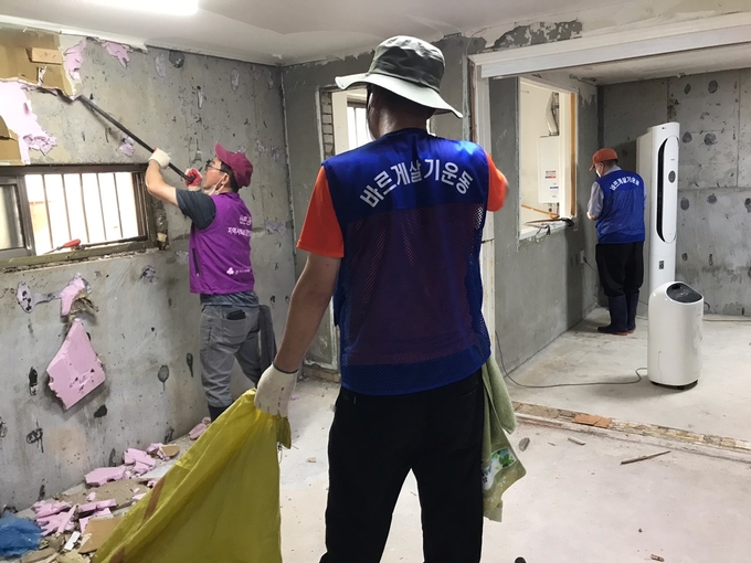 신촌동 사회단체 회원들이 안양7동 침수주택에서 도배작업을 벌이고 있다.(사진=안양시 제공)