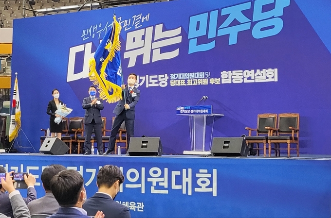 박정 전 위원장이 신임 임종성 위원장에게 꽃다발과 당기를 전달하며 축하 인사를 건넸자 임 위원장은 당기를 받아들고 힘차게 흔들었다. 임 의원은 수락연설에 앞서 당원 및 지지자들을 향해 큰 절을 올렸다. (사진=김혜진 기자)
