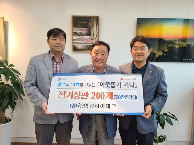김기영 영광하이테크등 관계자는 어려운이웃을 위해 써달라며 구정서 초월읍장에게 전기장판 200개를 전달하고 있다.(사진=광주시 제공)