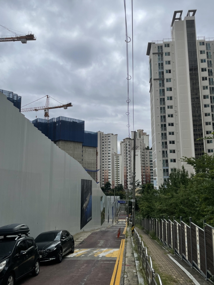 한화건설의 아파트 공사현장(좌)과 불과 20~30m 거리에 있는 대규모 아파트 단지. ( 사진 = 조경욱 기자 )