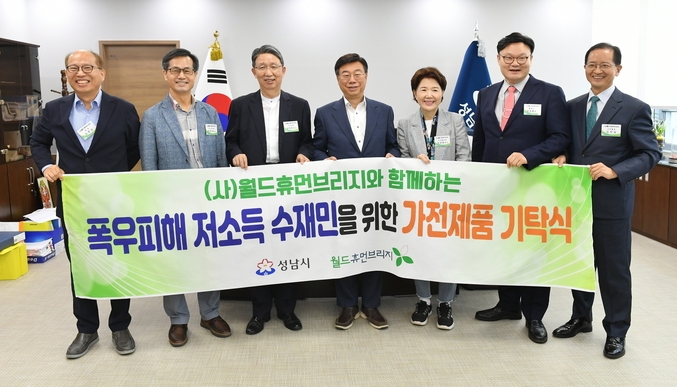 기탁식 후 김병삼 ㈔월드휴먼브리지 대표(사진 왼쪽 첫 번째)와 신상진 성남시장(사진 왼쪽에서 네 번째) 등 관계자들이 기념촬영을 하고 있다. (사진=성남시 제공)