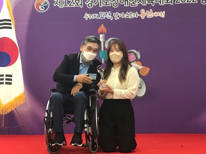 ·3일 용인특례시 미르스타디움 다목적홀에서 열린 제12회 경기도장애인체육대회 2022 용인 폐회식에서 수영 여자부에서 4관왕에 오르며 최우수선수(MVP)로 선정된 김미리(수원시·지체장애)가 이용운 경기도장애인체육회 부회장과 기념사진을 찍고 있다. (사진=정민수 기자)