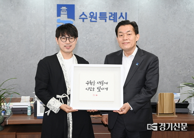 이재준 수원시장(오른쪽)과 김상훈 작가가 ‘수원을 새롭게 시민을 빛나게’ VI 켈리그래피를 들고 포즈를 취하고 있다. (사진=수원시 제공)